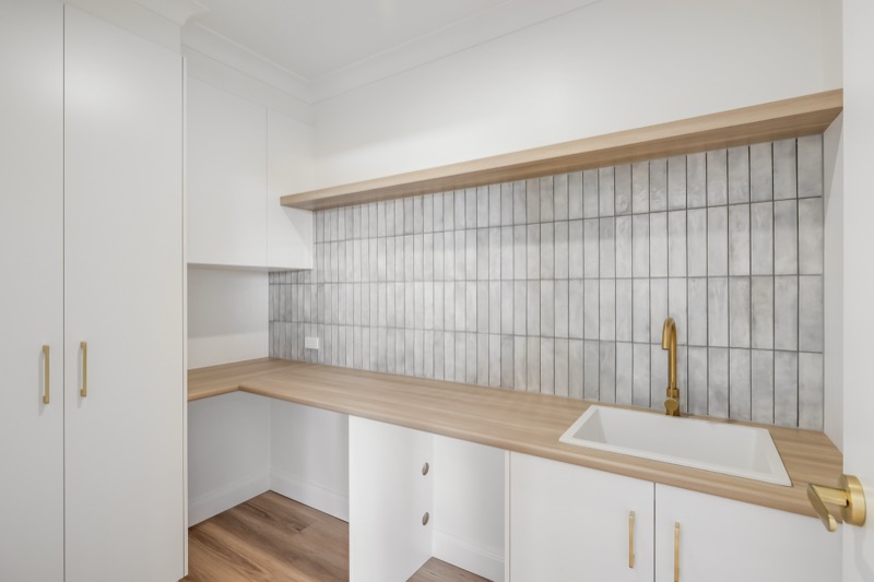 Laundry with timber benchtop and tiled splashback