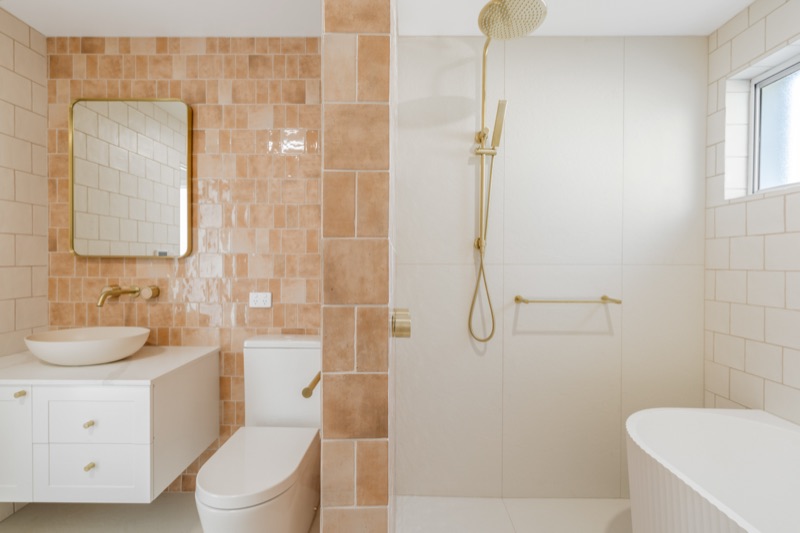 Bathroom with terracotta feature tiles and brass tapware