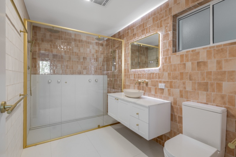 Ensuite with terracotta tiles and frameless shower