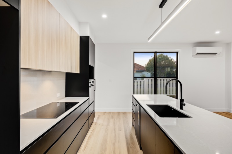 Kitchen detail with black benchtop and timber cabinetry