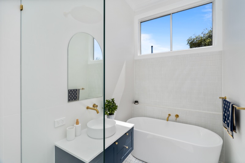 Bathroom with freestanding bath and arched mirror