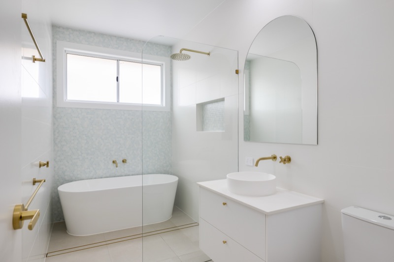 Bathroom with freestanding bath and arched mirror
